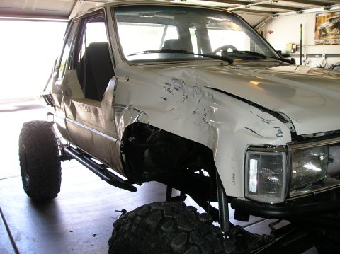 1986 Toyota Hilux - This 1986 Toyota Hilux shows extensive damage to its front fender and door, with a lifted suspension visible.