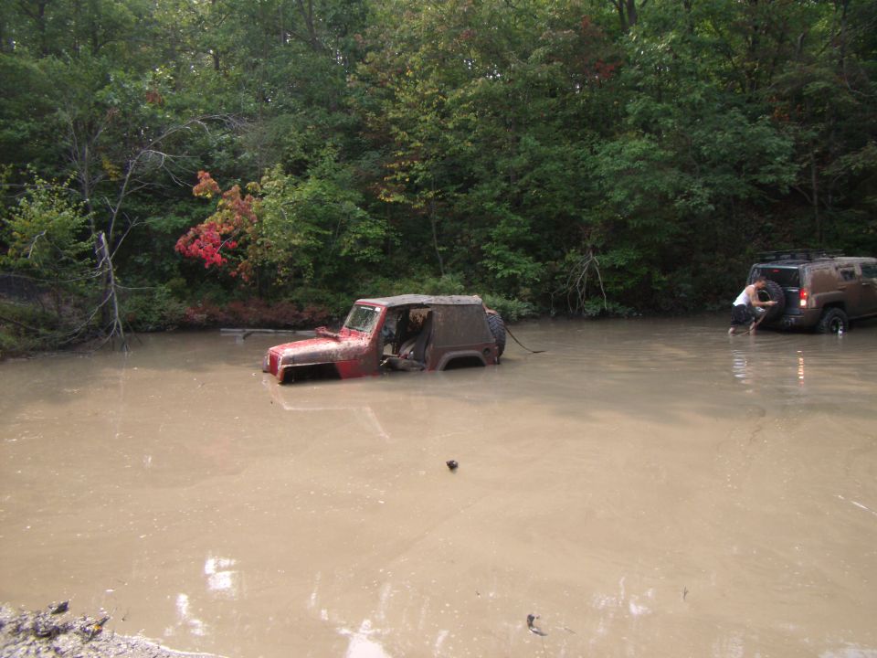 Red Jeep Wrangler submerged in mud, 2003 model year