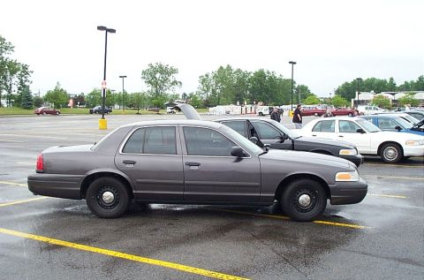 1991 Ford LTD Crown Victoria - Side view of a gray Ford Crown Victoria, parked in a lot with other vehicles visible.