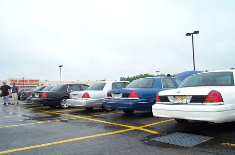 1991 Ford LTD Crown Victoria - Multiple Ford Crown Victoria Police Interceptors are parked in a lot under an overcast sky.