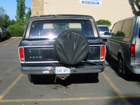 1978 Ford Bronco - The rear of a black 1978 Ford Bronco is visible, parked next to another vehicle.