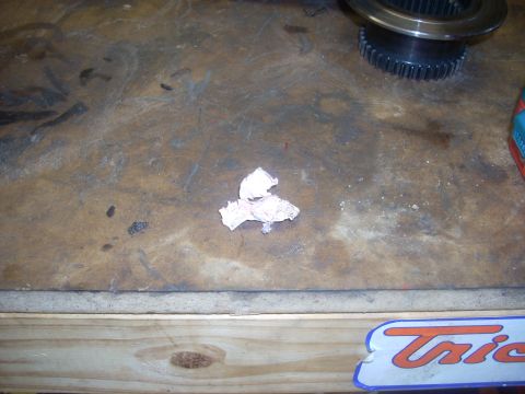 1992 Ford Bronco - A transfer case gear and a crumpled paper towel rest on a wooden workbench surface.