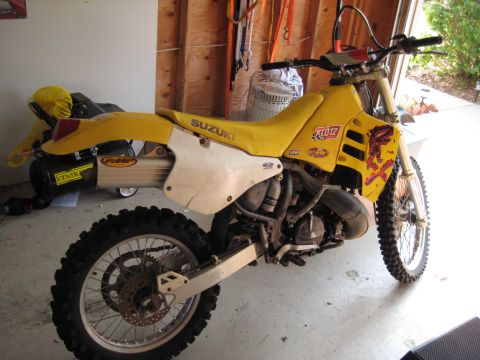 1993 Suzuki RMX250 - A yellow 1993 Suzuki RMX250 dirt bike is parked in a garage.