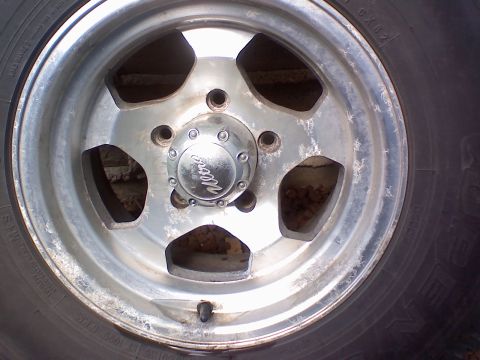 1996 Ford Bronco - A close-up of a Weld brand wheel and tire, showing the center cap and spokes.
