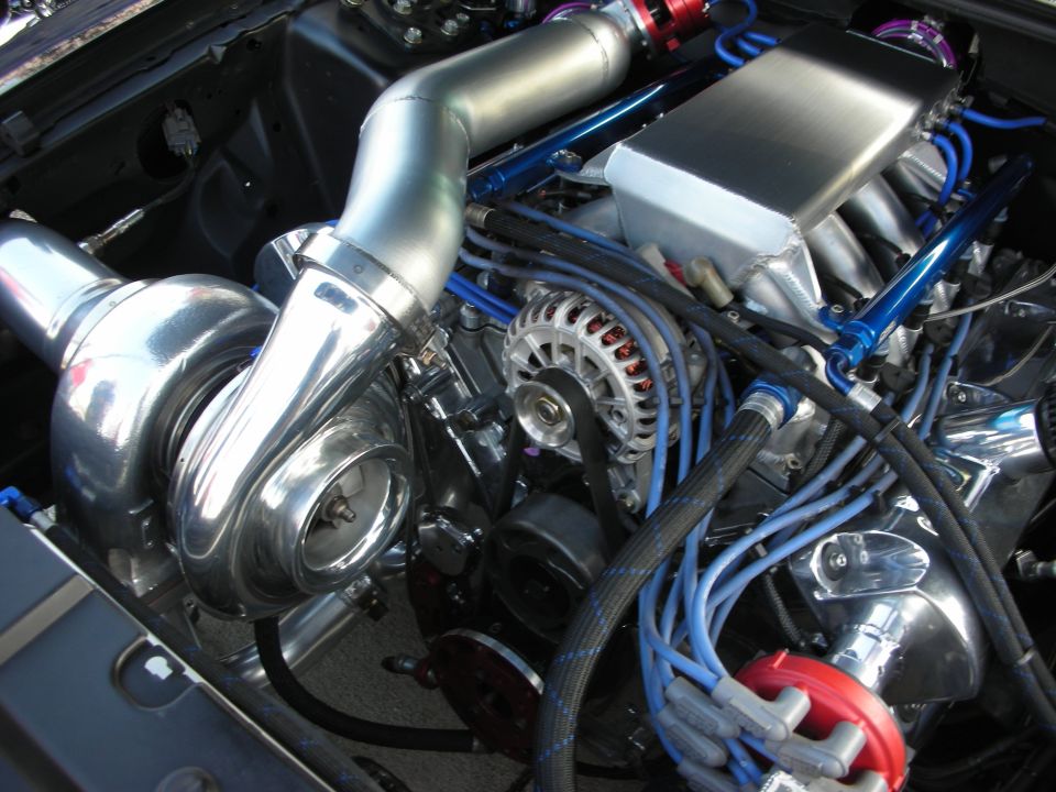 Close-up of a turbocharged V8 engine with chrome intake manifold and blue spark plug wires