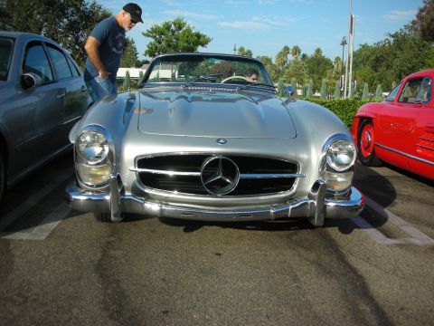 1998 Ford Crown Victoria - Silver Mercedes-Benz 300 SL convertible with a red car visible to the right.