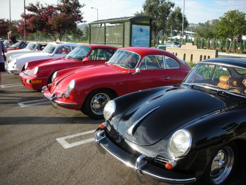1998 Ford Crown Victoria - A line of classic Porsches, including a black 356 in the foreground, are parked together.