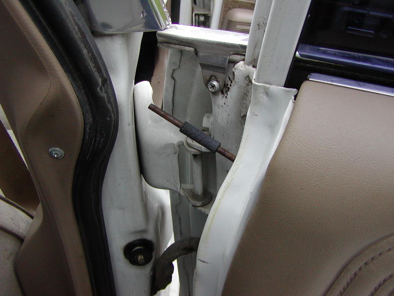 Interior door hinge mechanism with visible rod and rubber sleeve