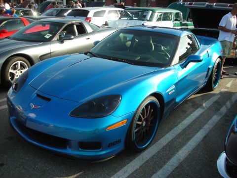 1998 Ford Crown Victoria - A blue Chevrolet Corvette C6 is parked at a car meet, showing off its custom wheels.
