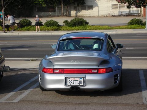 1998 Ford Crown Victoria - A silver Porsche 911 Turbo is parked in a lot, viewed from the rear.