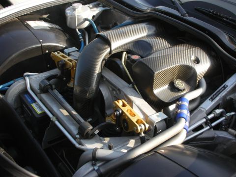 1998 Ford Crown Victoria - Close-up of a modified engine bay carbon fiber components and gold engine mounts.