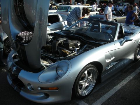 1998 Ford Crown Victoria - A silver convertible sports car is displayed with its hood open, revealing the engine compartment.