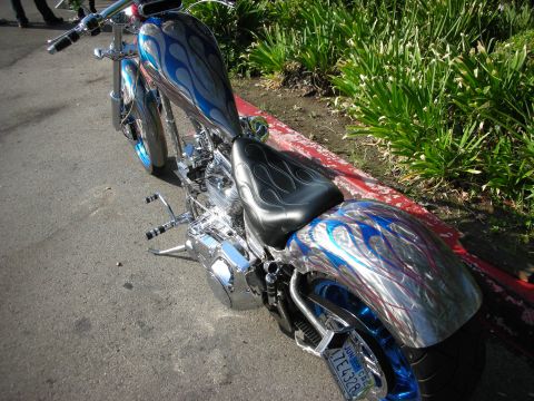 1998 Ford Crown Victoria - A custom motorcycle with a flame paint job is parked on the side of the road.