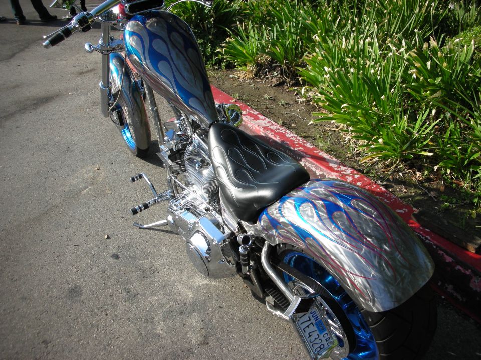 Custom motorcycle with blue flames on tank and fender, side view