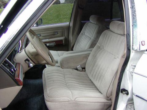 1991 Ford LTD Crown Victoria - The interior of a sedan features tan velour seats and a beige dashboard.