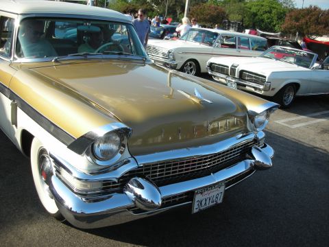 1998 Ford Crown Victoria - Packard Caribbean convertible parked at a car meet, with other vehicles in the background.