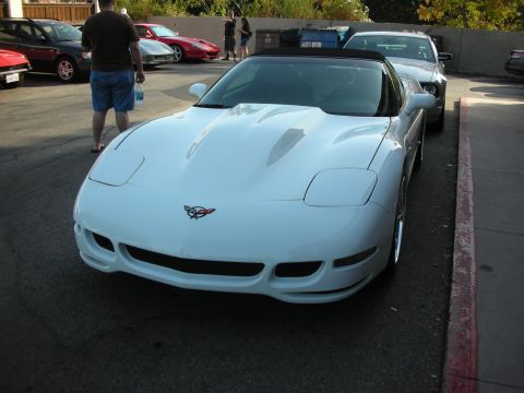 1998 Ford Crown Victoria - White C5 Corvette convertible parked next to other vehicles at an outdoor gathering.