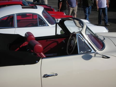 1998 Ford Crown Victoria - Close-up of a vintage convertible's interior, showing red upholstery and a white steering wheel.