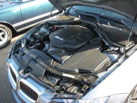 1998 Ford Crown Victoria - Engine bay of a BMW M3, with another vehicle visible in the background.
