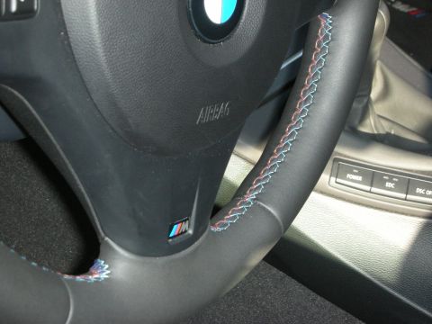 1998 Ford Crown Victoria - Interior view of a steering wheel with M badging and distinctive tri-color stitching.