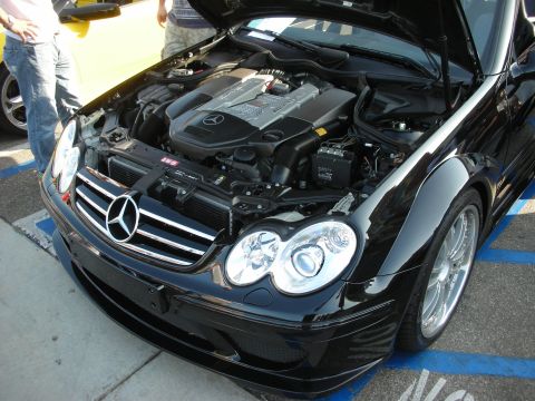 1998 Ford Crown Victoria - A black Mercedes-Benz coupe is shown with its hood open, revealing the engine and front grille.