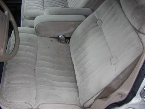 1991 Ford LTD Crown Victoria - Interior view of a car's front seats and armrests, with a partial view of the steering wheel.
