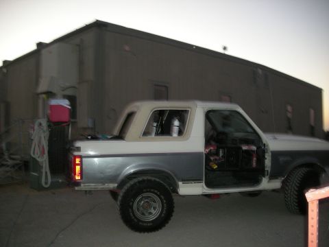 1991 Ford Bronco - Side view of a 1991 Ford Bronco, doors off, parked outdoors at dusk.