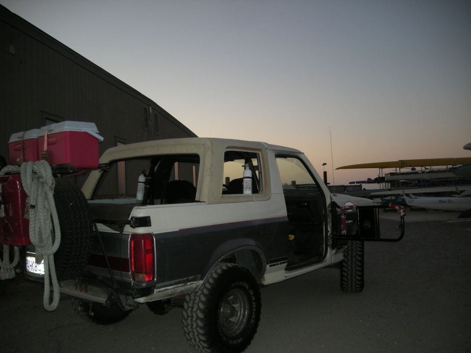 1991 Ford Bronco with soft top, spare tire, and coolers on rear carrier