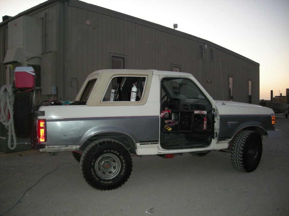 Two-tone white and gray 1991 Ford Bronco with doors open, parked outdoors