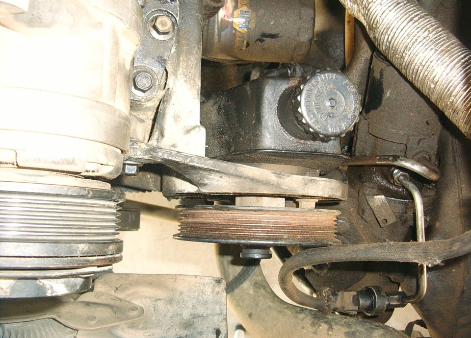 Underhood close-up of belt-driven pulleys and an idler