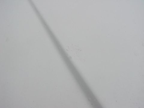 1991 Ford LTD Crown Victoria - A shadow falls across the plain white surface of a car's hood.