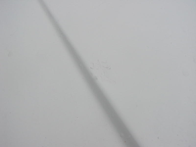 Close-up of a white car hood with a shadow across it