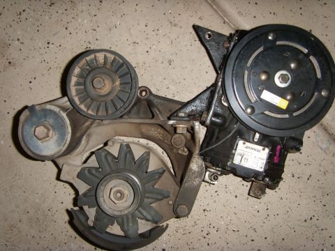 1989 Ford F-250 - This assembly includes an AC compressor, alternator, and belt tensioner, likely for an older vehicle.