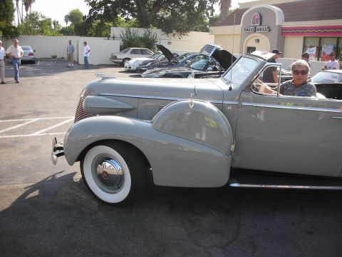 1998 Ford Crown Victoria - A classic gray convertible is parked in a lot, with other vehicles and a Taco Bell in the background.