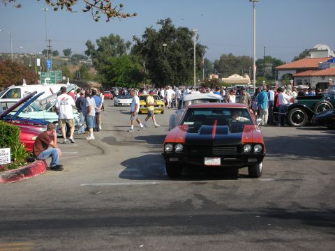 1998 Ford Crown Victoria - A crowd gathers around various vehicles at an outdoor car meet.