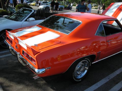 1998 Ford Crown Victoria - Rear view of an orange 1969 Camaro with white stripes at a car meet.