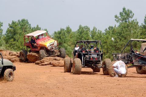 1987 Suzuki Samurai - Off-road vehicles tackle a challenging course with multiple vehicles visible.