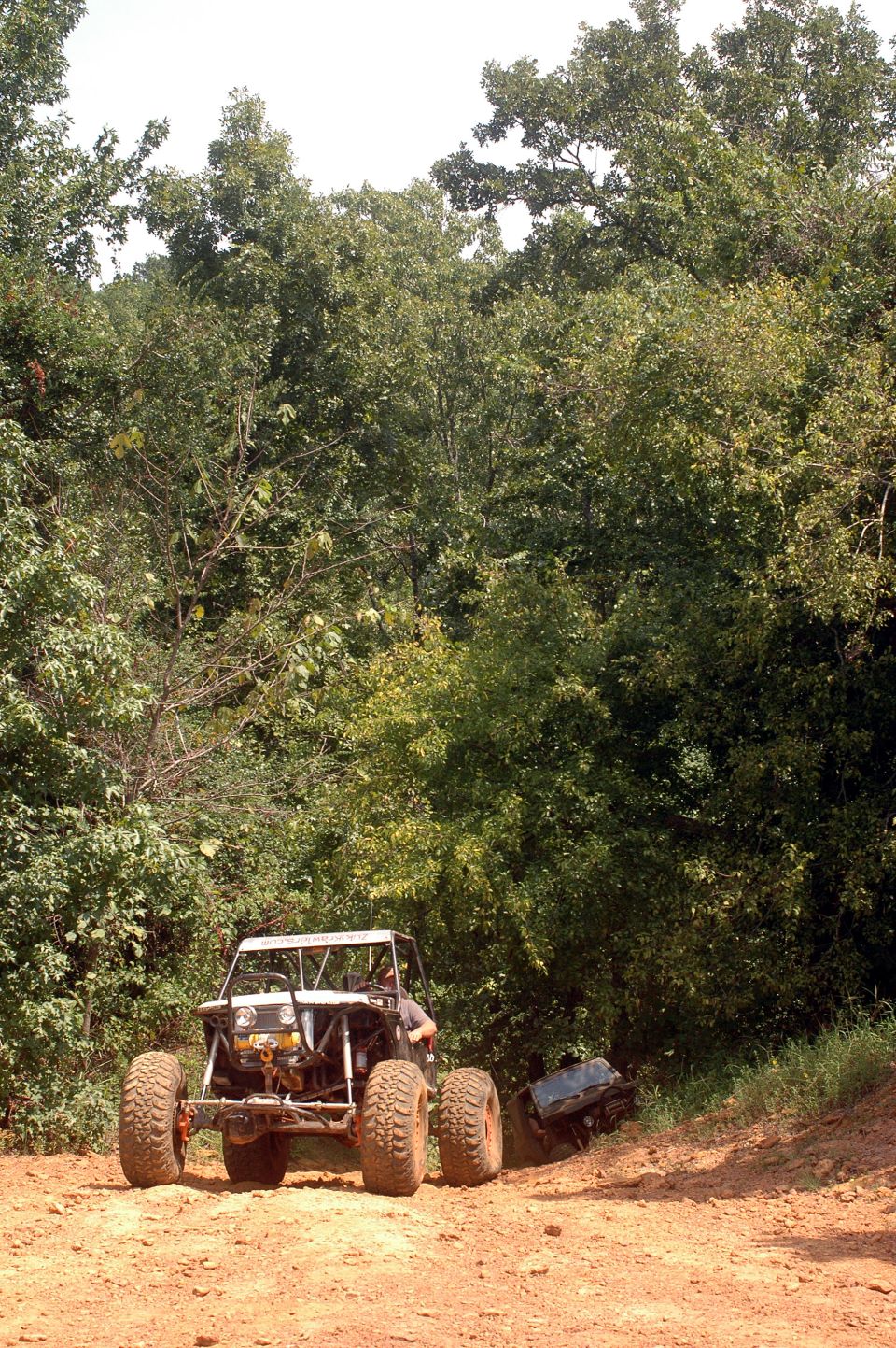 Off-road buggy with exposed engine and large tires on a dirt path