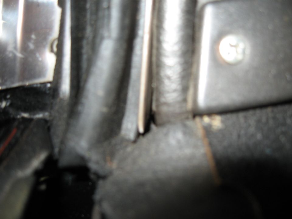 Close-up of black car interior trim with visible screw and rubber seal