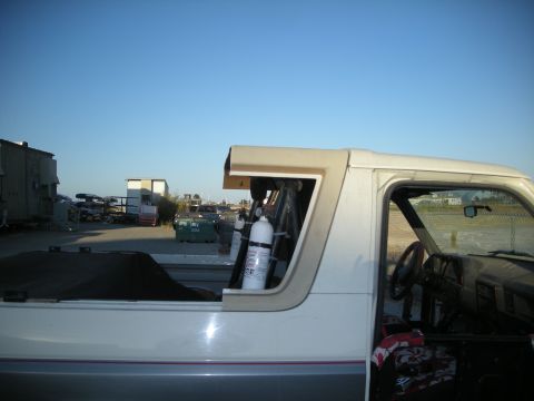 1991 Ford Bronco - Side view of a 1991 Ford Bronco showing the interior and bed with a nitrous oxide bottle.