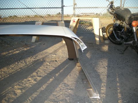 1991 Ford Bronco - A white vehicle roof panel is supported by sawhorses outdoors, with a motorcycle visible to the right.
