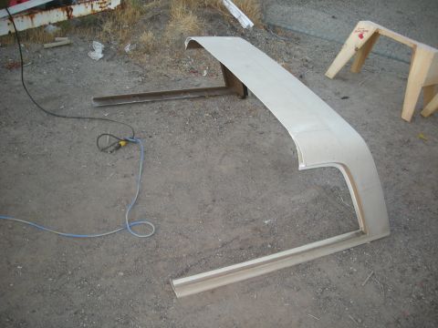 1991 Ford Bronco - A raw car body panel sits on the ground, awaiting further work, with tools nearby.