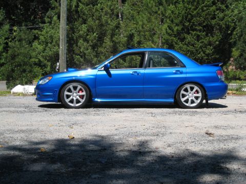 2007 Subaru Impreza - Side view of a blue 2007 Subaru Impreza sedan with aftermarket wheels.