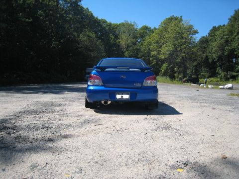2007 Subaru Impreza - Rear view of a blue 2007 Subaru Impreza sedan with a spoiler and aftermarket exhaust.