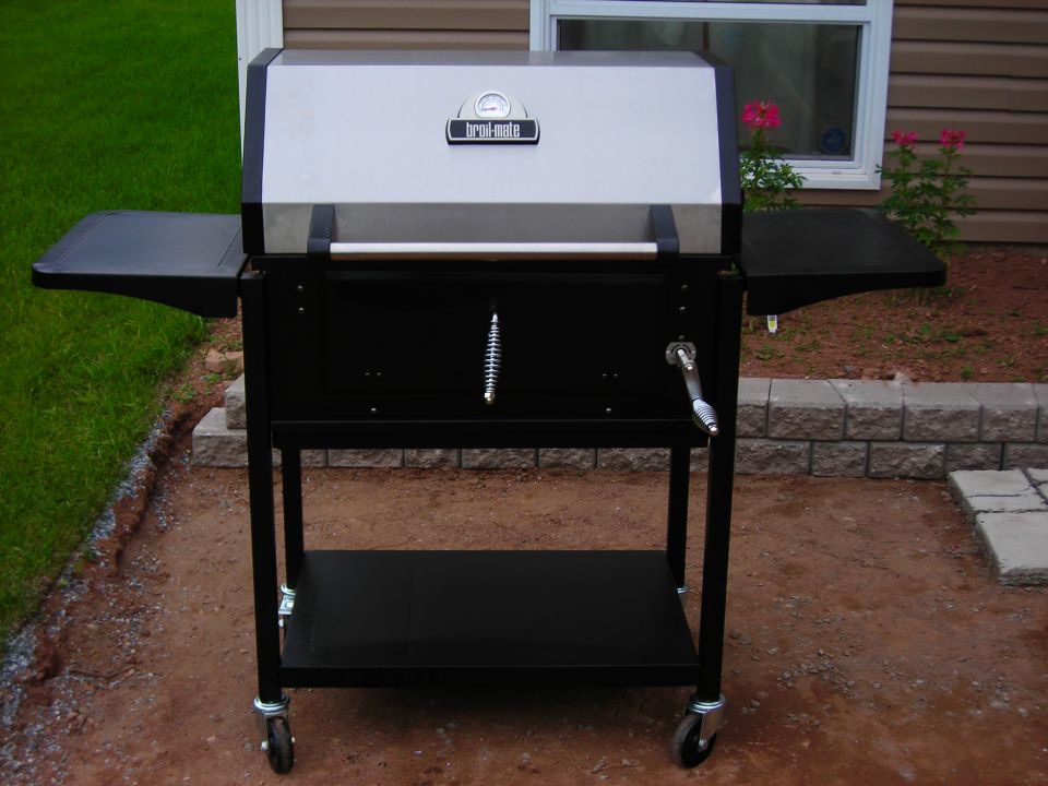 Broil-Mate gas grill with side shelves and bottom rack, parked on a patio