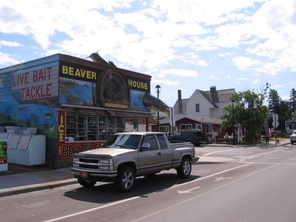 Silver GMC Sierra pickup truck parked on street, 3q-front view. Beaver House building in background