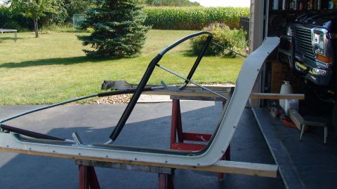 1979 Ford Bronco - A disassembled Ford Bronco door frame and roll bar are laid out on sawhorses for repair or restoration.