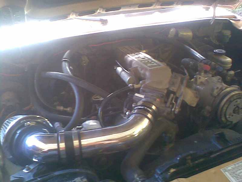 engine bay with chrome intake piping and a 2.9L engine label