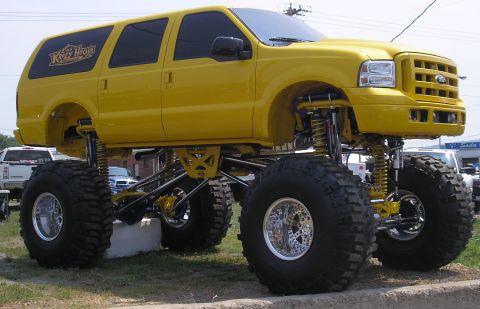1995 Ford Bronco - This heavily modified yellow SUV features oversized tires and a custom suspension lift, with "Ketch House" branding visible on the rear win…
