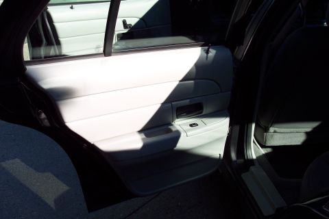 2001 Ford Crown Victoria - The interior of a car, focusing on the passenger side door panel and seat, with distinct shadows cast by the sunlight.